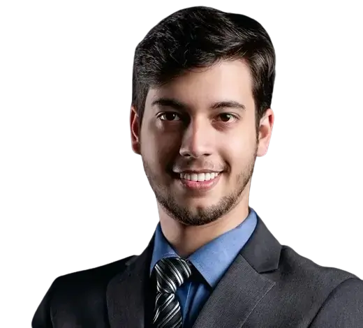Smiling man in a dark suit and blue shirt facing the camera, portrait-style headshot.